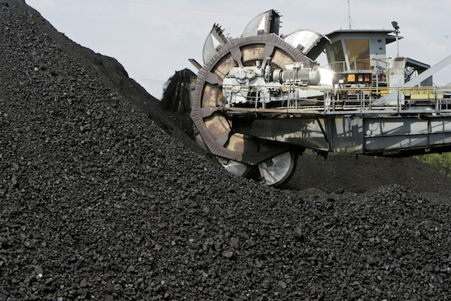 A giant scoop lifts coal on to a conveyor belt at an open pit coal mine. PHOTO Bloomberg